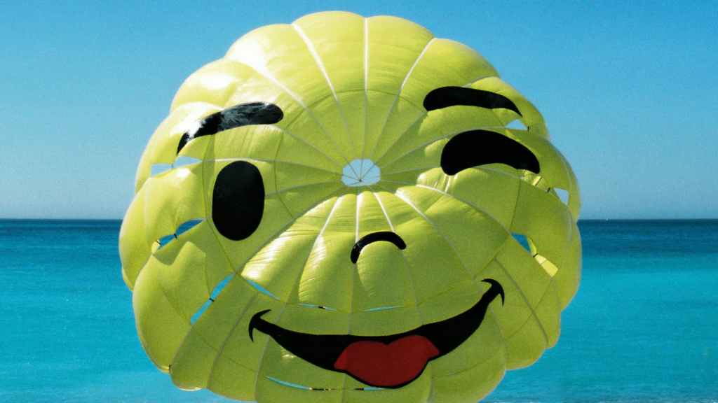 Smiley face parachute above the ocean, symbolizing friendly mobile design.