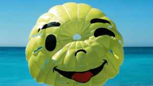 Smiley face parachute above the ocean, symbolizing friendly mobile design.