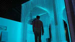 A man walks toward a mesmerizing structure illuminated by vibrant blue LED lights, symbolizing the captivating effect of visual hierarchy drawing users in.