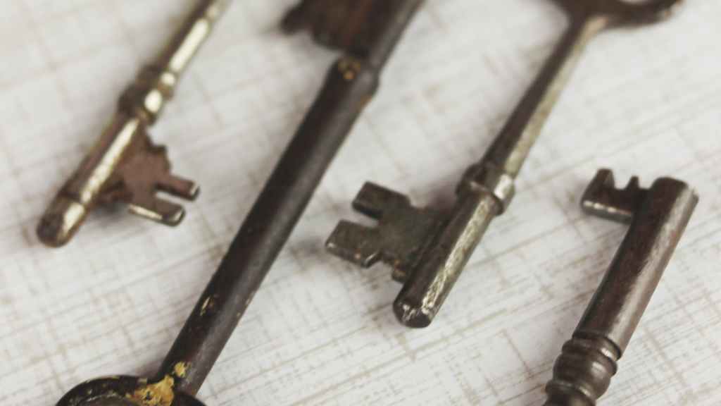 Four vintage keys on a white surface, representing time-tested keyword research strategies.