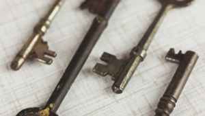 Four vintage keys on a white surface, representing time-tested keyword research strategies.