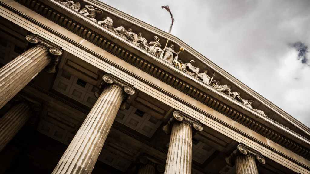 A picture looking up at a classic stone architecture court house. The many large stone columns reaching to the stone roof that appears to reach to the sky. Symbolic of the heights lawyers web sites can reach with proper SEO strategies.